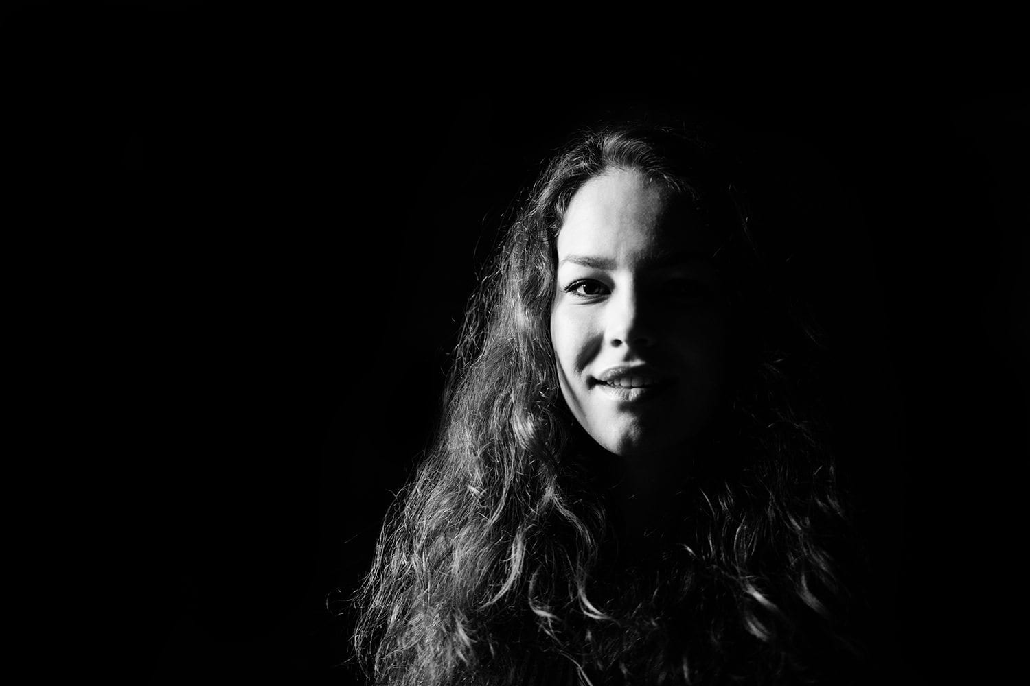 black and white portrait of a beautiful brunette girl with black background
