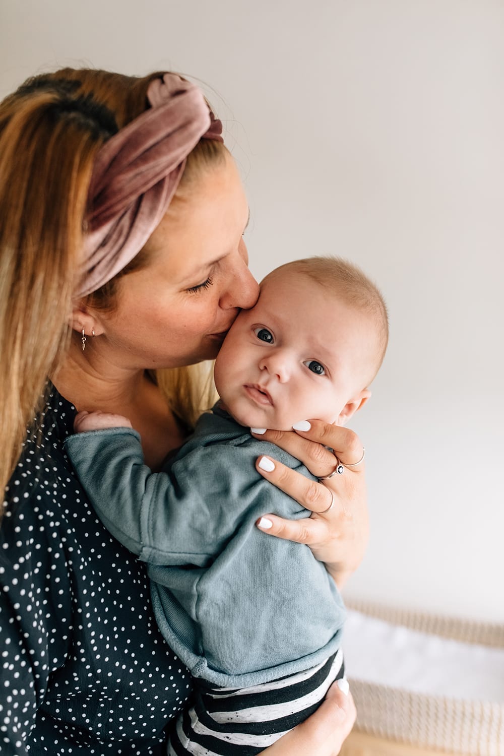 foto van een vrouw die hun baby kust tijdens een gezinsreportage aan huis met missjettle