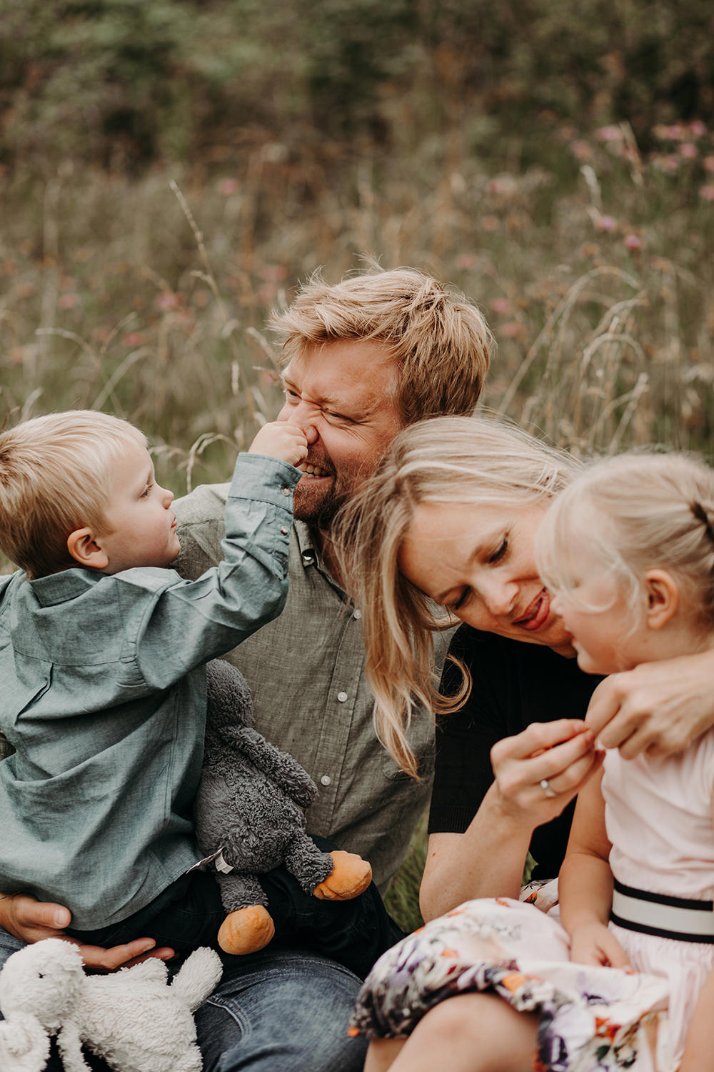 Gezinsfotoshoot buiten met kinderen en knuffelbeer.