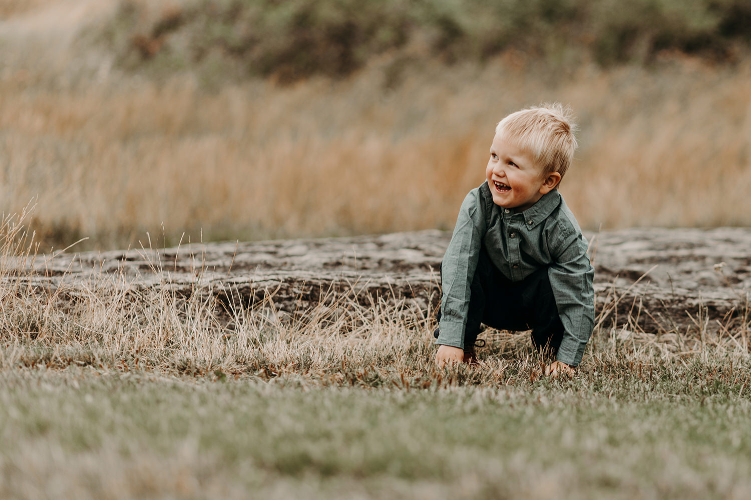 Gezinsfotoshoot buiten met een jongetje in het gras.