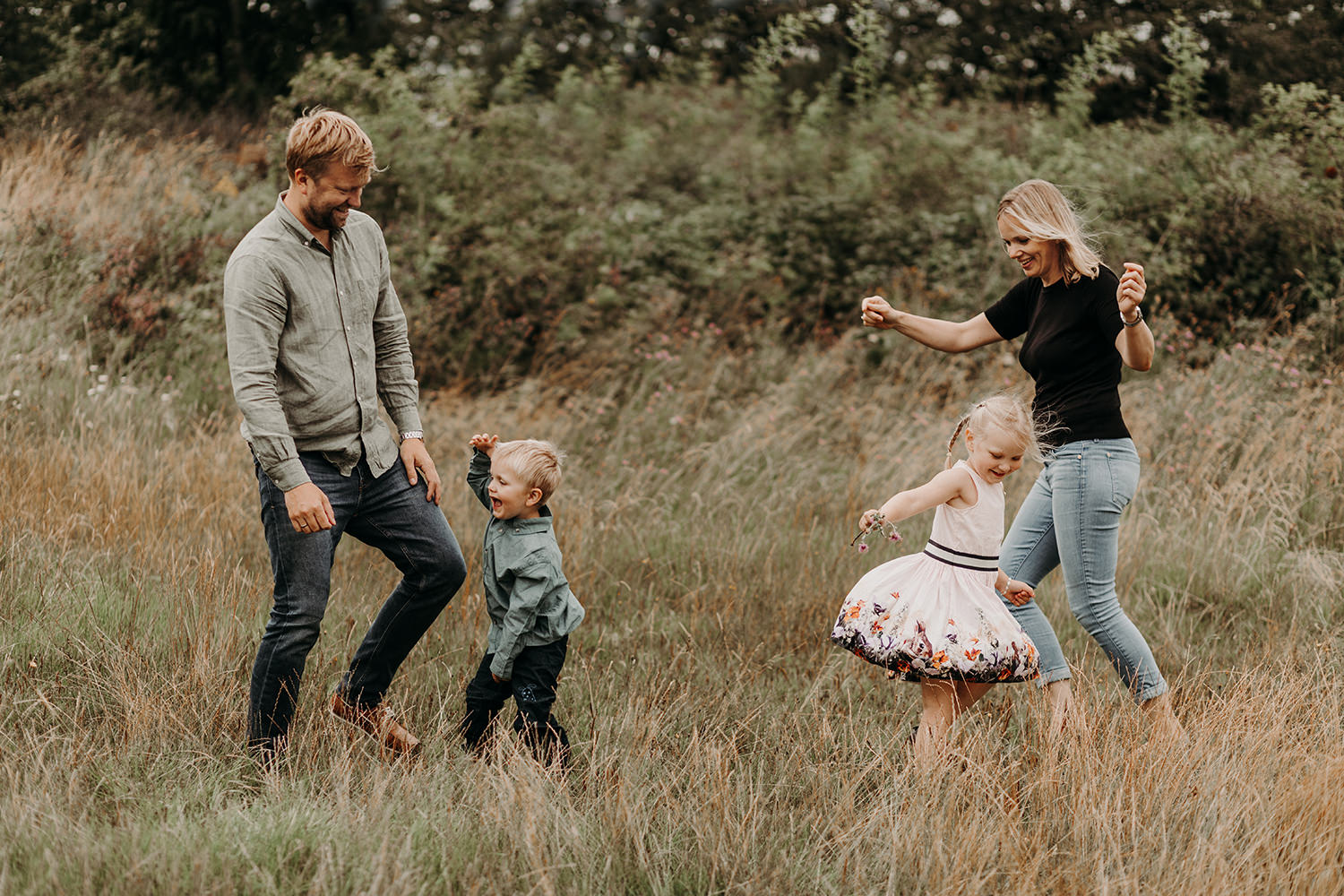 Gezinsfotoshoot buiten in een veld met kinderen.
