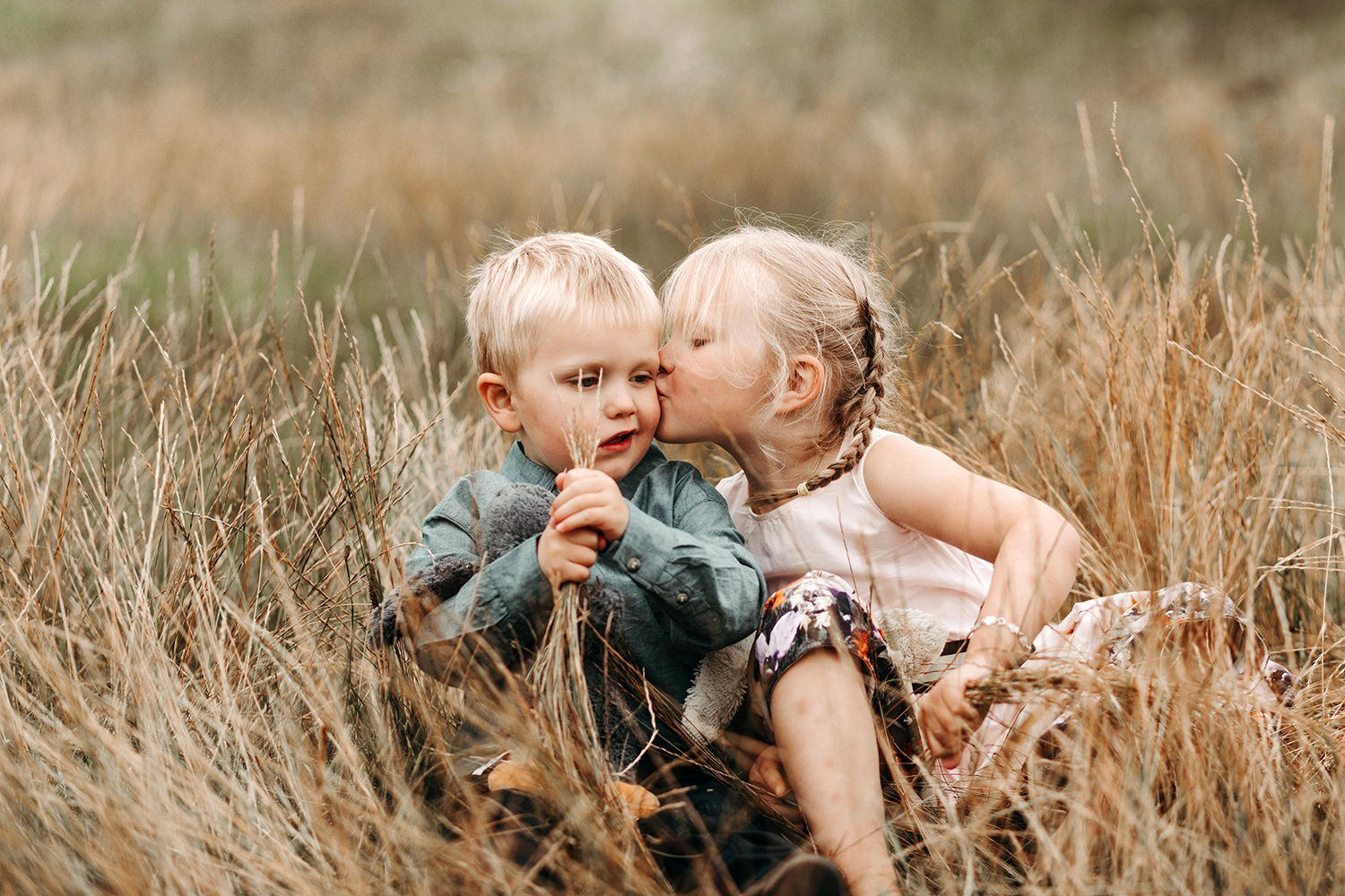 Gezinsfotoshoot buiten met kinderen in een veld.