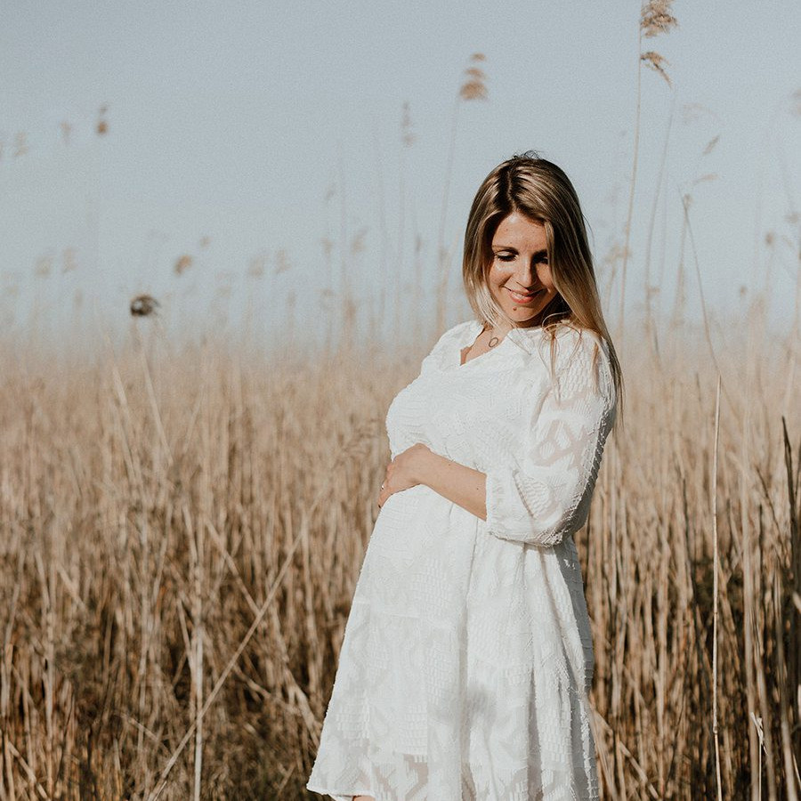 zwangerschapsfotoshoot met vrouw in witte jurk