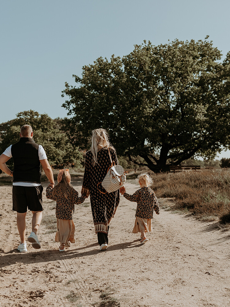 foto van een gezin van vier van achteren voor een artikel met kledingtips voor een gezinsfotoshoot