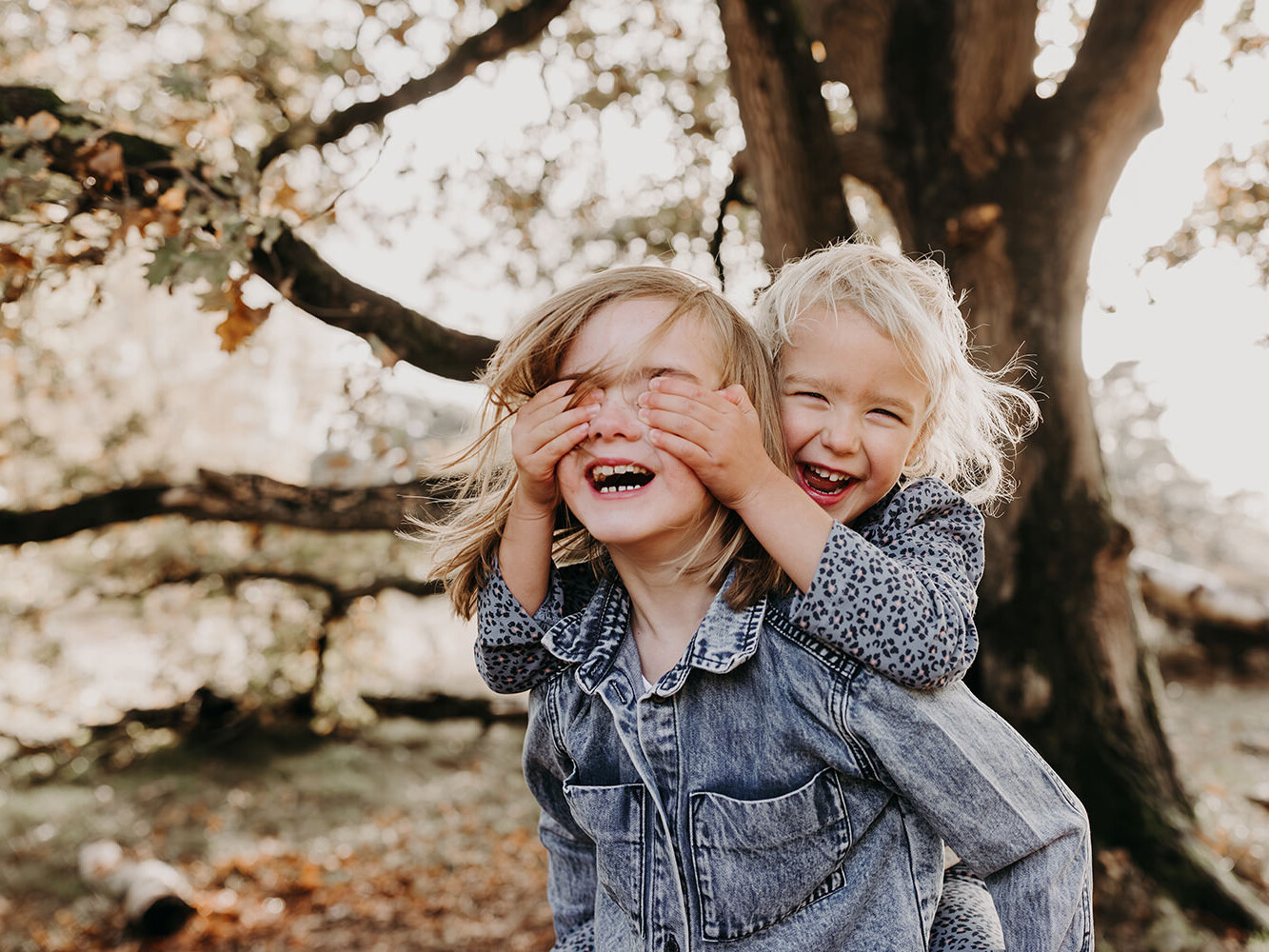 Twee lachende zussen tijdens een herfst mini fotoshoot in Huizen met Picturelyspoken