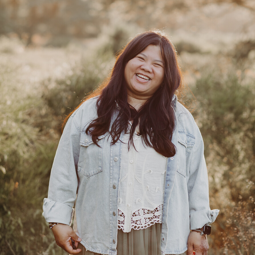 Lachende asiatische vrouw met mooi lang zwart haar in de natuur tijdens een personal branding fotoshoot