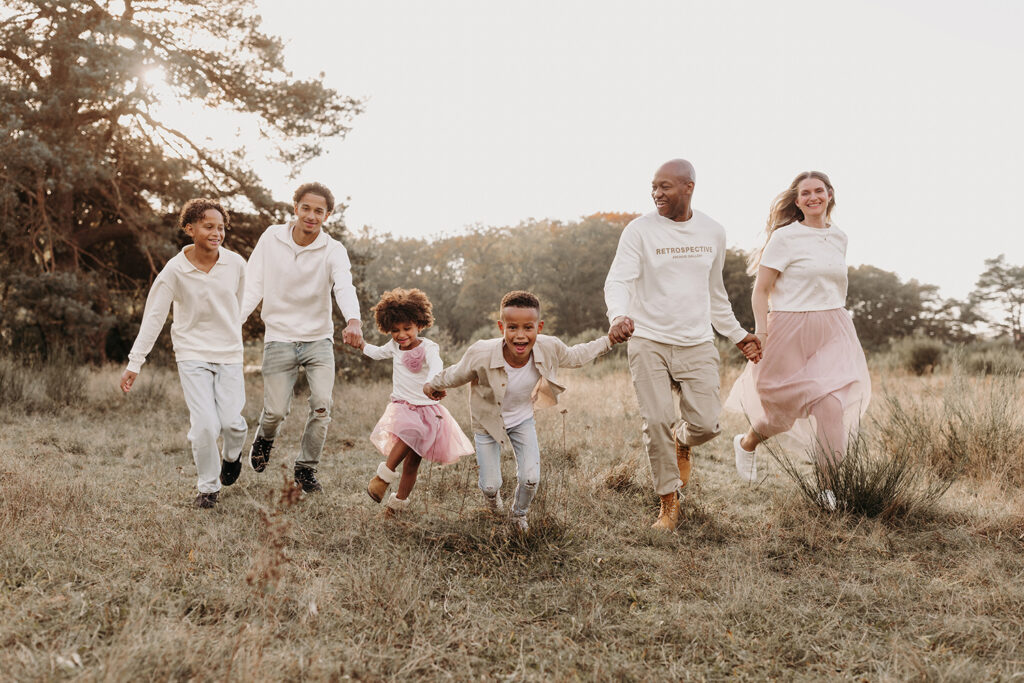Spontane, leuke foto van een familie tijdens een familiefotoshoot buiten in golden hour licht