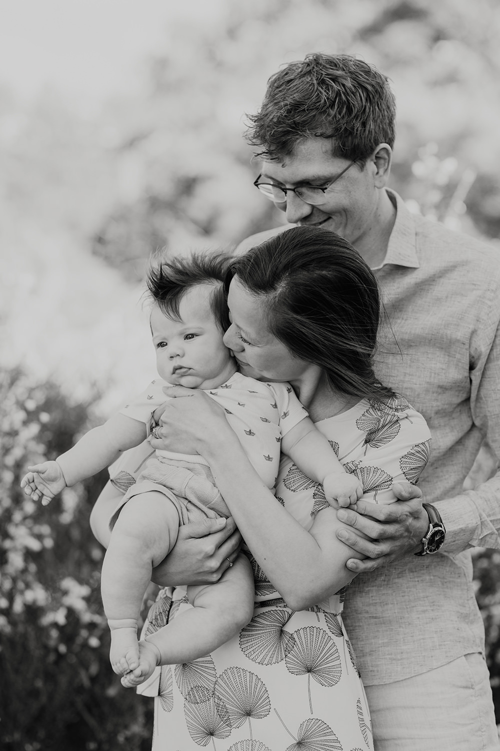 zwart wit foto van een jong gezin met baby op buiten locatie op een mini fotoshoot met Picturelyspoken