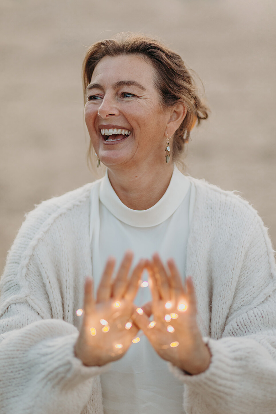 Lifestyle foto van vrouw in witte kleren en licht op de handen tijdens een personal branding fotoshoot